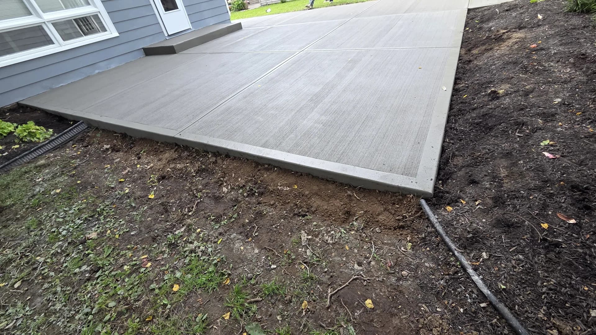 Workman finishing concrete walkway edge